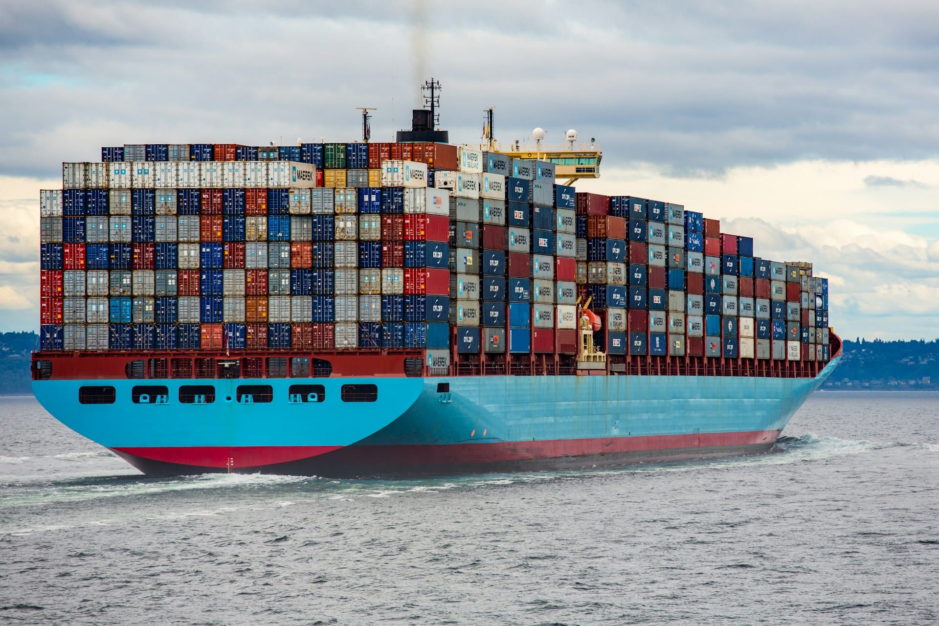 A large freight ship at sea, stacked high with containers